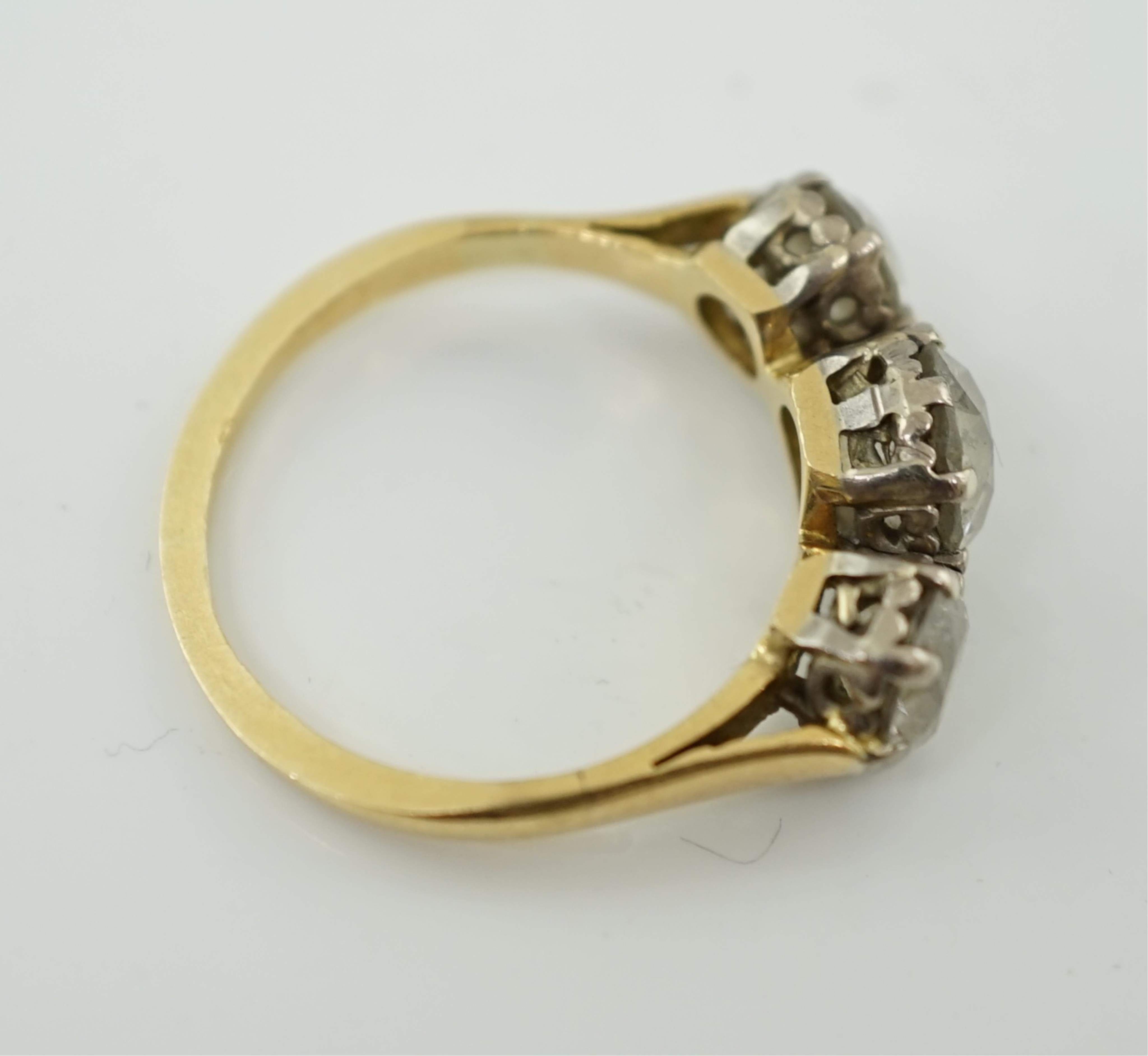 An unmarked gold and three stone diamond set ring